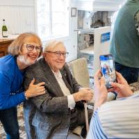 Sheree Rizzardi leaning over and posing for a photo with Don Lubbers